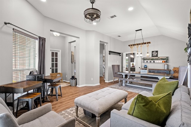 living room featuring ceiling fan, lofted ceiling, and light wood-type flooring