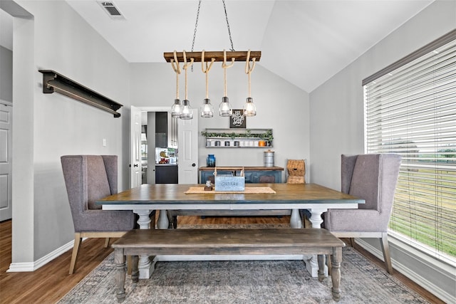 dining space with dark hardwood / wood-style flooring and lofted ceiling