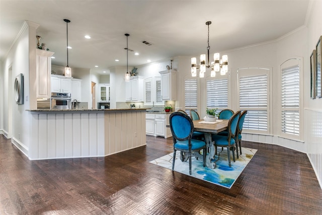 kitchen featuring pendant lighting, stainless steel oven, and white cabinets