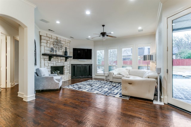 living room featuring dark hardwood / wood-style flooring, crown molding, and a fireplace