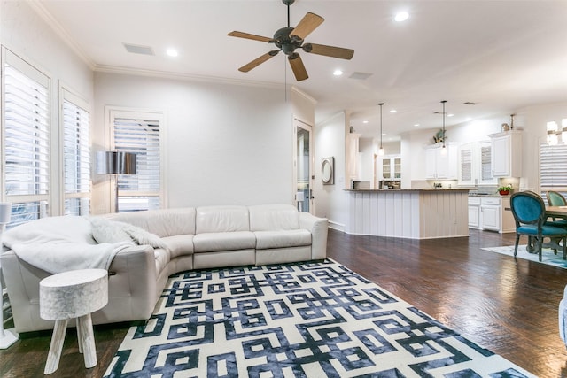 living room with crown molding, ceiling fan, and dark hardwood / wood-style floors