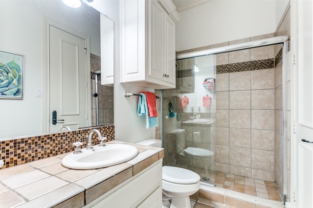 bathroom featuring crown molding, vanity, tasteful backsplash, toilet, and walk in shower