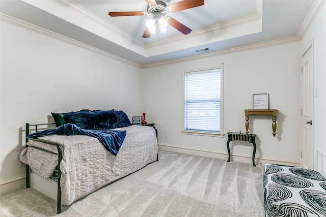 bedroom with crown molding, carpet, ceiling fan, and a tray ceiling