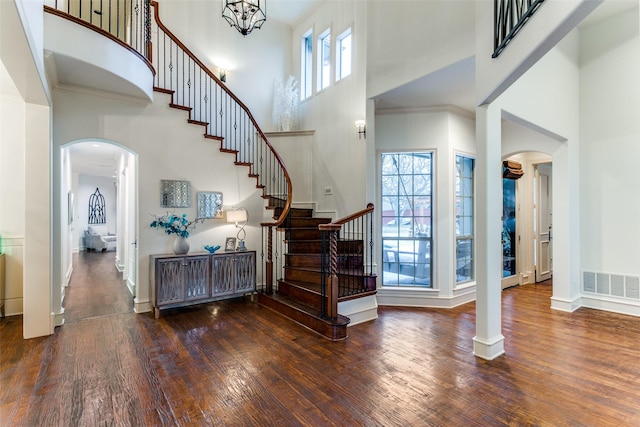 foyer featuring crown molding, a towering ceiling, and dark hardwood / wood-style floors