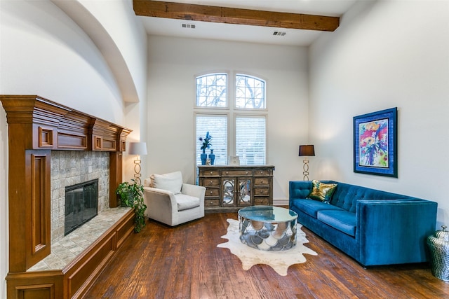 living room featuring dark wood-type flooring, a towering ceiling, and beam ceiling