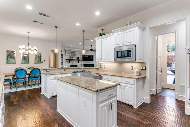 kitchen with decorative light fixtures, white cabinets, a center island, kitchen peninsula, and stainless steel appliances