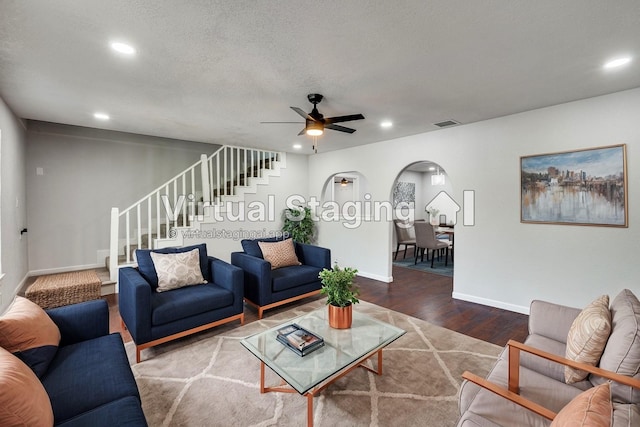 living room featuring ceiling fan, hardwood / wood-style floors, and a textured ceiling