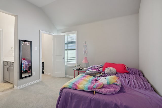 bedroom featuring vaulted ceiling, light carpet, and ensuite bathroom