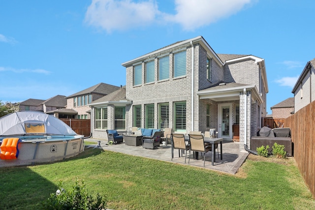 back of house featuring a yard, an outdoor hangout area, and a patio area