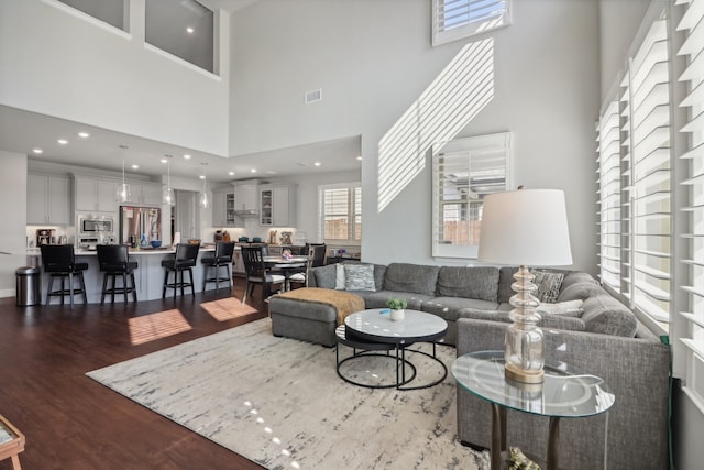 living room with a high ceiling and dark hardwood / wood-style floors