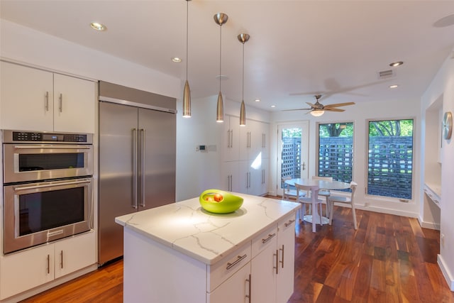 kitchen featuring a center island, dark hardwood / wood-style flooring, white cabinetry, and appliances with stainless steel finishes