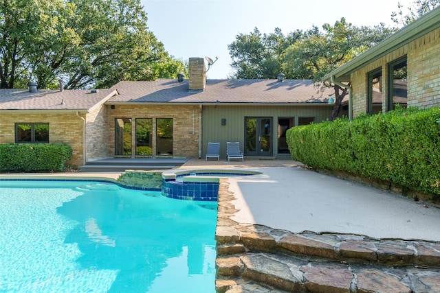 view of swimming pool featuring an in ground hot tub and a patio