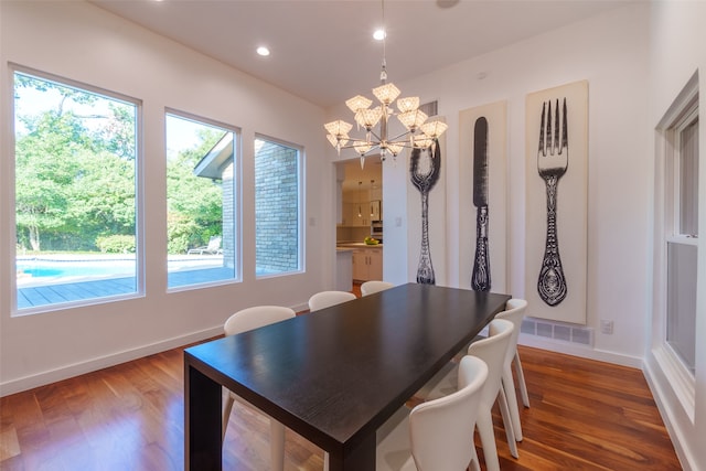 dining room with dark hardwood / wood-style flooring and an inviting chandelier