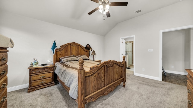 carpeted bedroom featuring lofted ceiling, ceiling fan, and ensuite bath