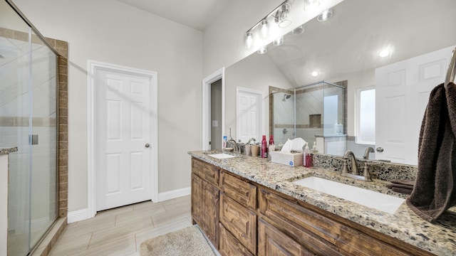 bathroom with lofted ceiling, vanity, and walk in shower