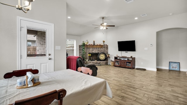 living room with a fireplace, vaulted ceiling, hardwood / wood-style flooring, and ceiling fan