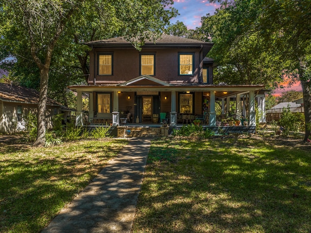 view of front of home with a porch and a lawn