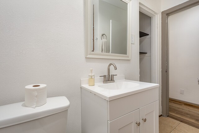 bathroom featuring vanity, toilet, and hardwood / wood-style floors