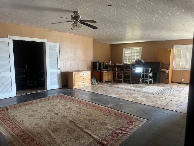 interior space featuring wooden walls and ceiling fan