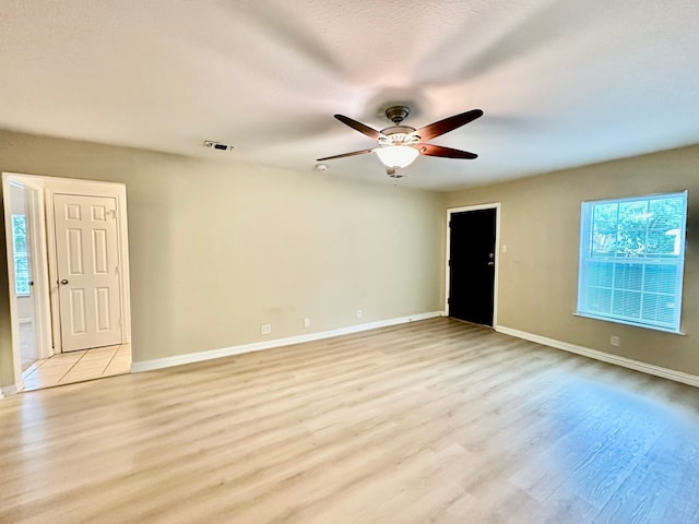 unfurnished room with a textured ceiling, light hardwood / wood-style flooring, and ceiling fan