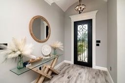 foyer featuring light wood-type flooring and vaulted ceiling