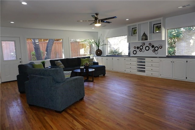 living room with dark wood-type flooring, a healthy amount of sunlight, ceiling fan, and beverage cooler