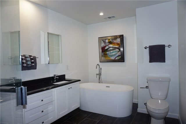 bathroom featuring a bath, toilet, and vanity