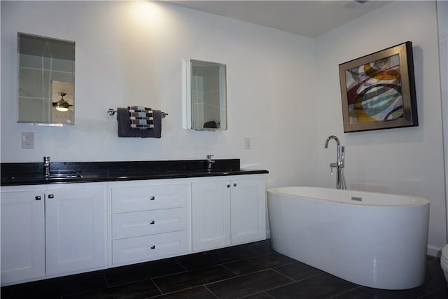 bathroom featuring tile patterned floors, a tub to relax in, and vanity