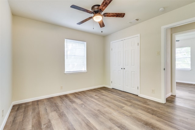 unfurnished bedroom featuring ceiling fan, light hardwood / wood-style floors, and a closet