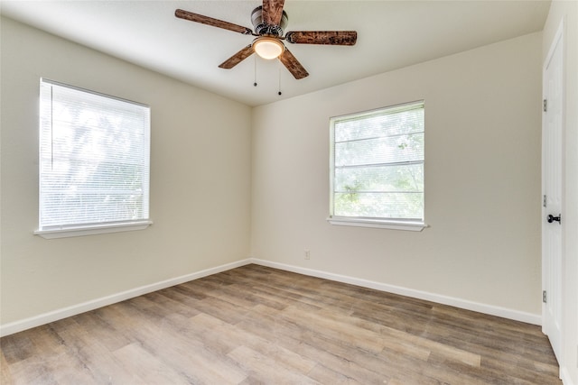 spare room featuring ceiling fan, plenty of natural light, and light wood-type flooring