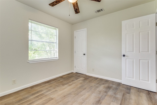 empty room with ceiling fan and light hardwood / wood-style floors