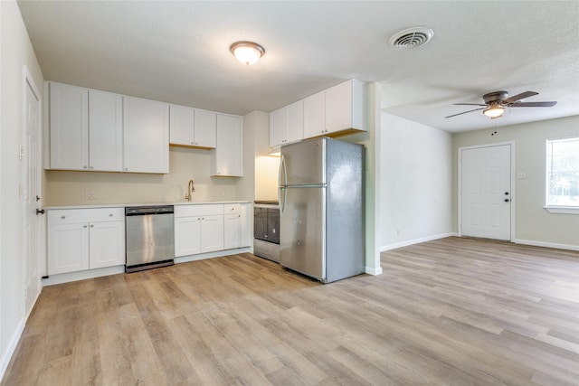 kitchen with stainless steel appliances, ceiling fan, sink, light hardwood / wood-style flooring, and white cabinetry