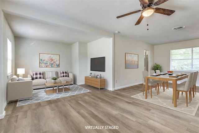 living room with ceiling fan and light wood-type flooring