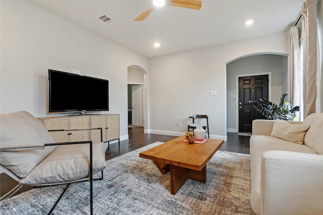 living room featuring ceiling fan and dark hardwood / wood-style floors