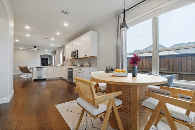 dining area with dark wood-type flooring and ceiling fan