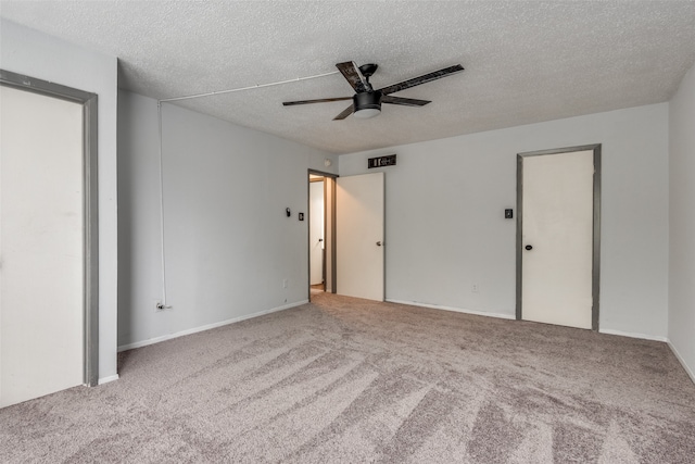 carpeted empty room featuring ceiling fan and a textured ceiling