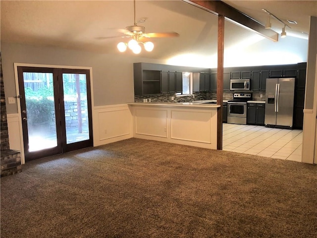 kitchen with light carpet, backsplash, stainless steel appliances, ceiling fan, and vaulted ceiling with beams