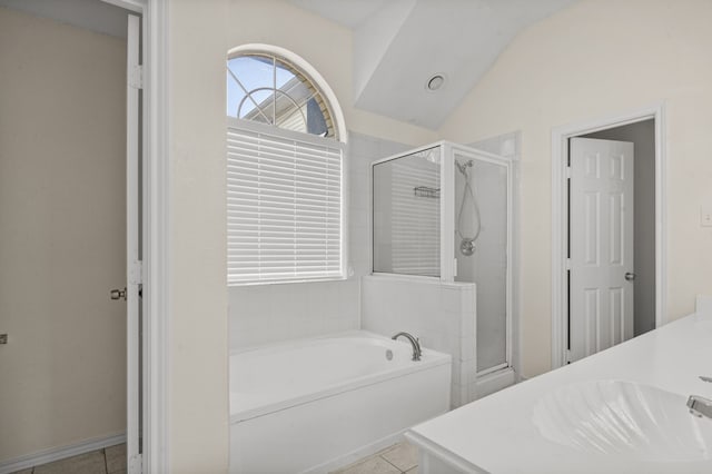 bathroom with plus walk in shower, tile patterned floors, lofted ceiling, and vanity