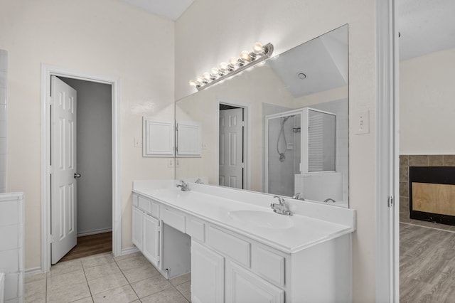 bathroom featuring tile patterned floors, a shower with shower door, lofted ceiling, and vanity