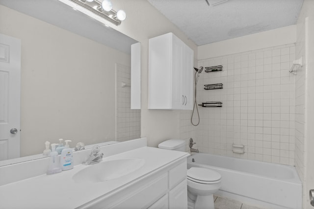 full bathroom featuring a textured ceiling, vanity, toilet, tiled shower / bath, and tile patterned floors