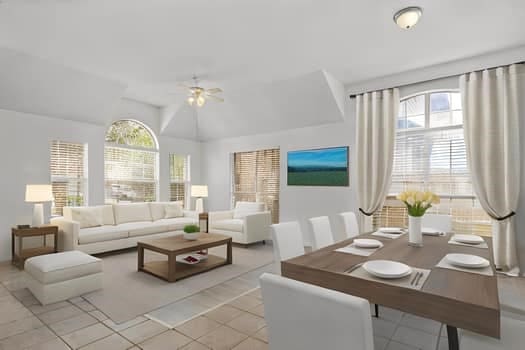 living room featuring lofted ceiling, light tile patterned floors, and ceiling fan