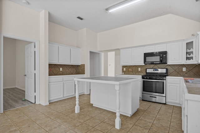 kitchen featuring stainless steel range oven, a center island, tasteful backsplash, and white cabinetry