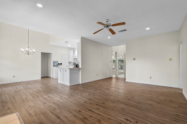 unfurnished living room with wood-type flooring and a textured ceiling