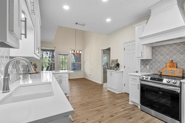 kitchen featuring white cabinetry, electric range, sink, light hardwood / wood-style floors, and custom exhaust hood