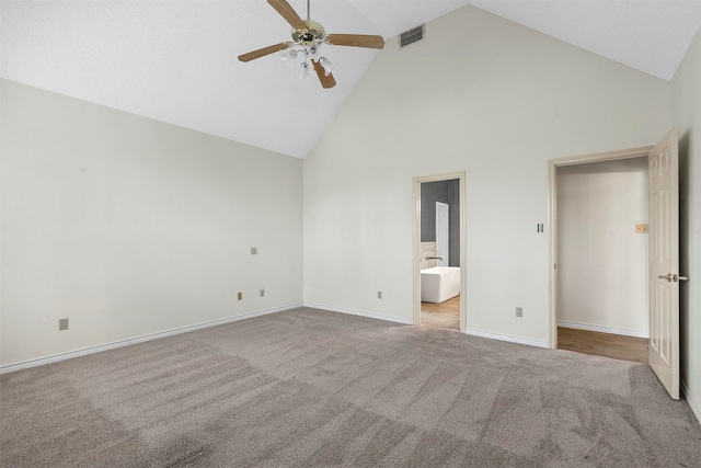 unfurnished bedroom with ensuite bath, ceiling fan, high vaulted ceiling, and light carpet