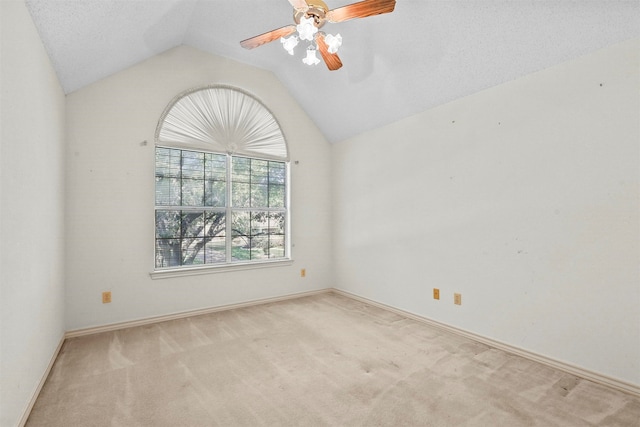 carpeted empty room featuring a textured ceiling, vaulted ceiling, and ceiling fan