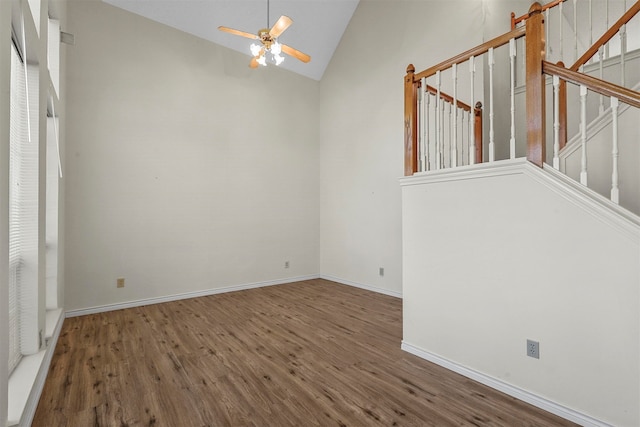 unfurnished living room with ceiling fan, dark wood-type flooring, and high vaulted ceiling