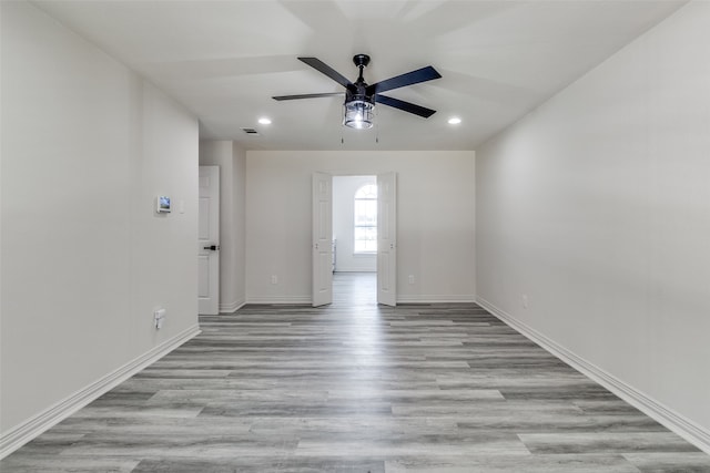 spare room with light wood-type flooring and ceiling fan