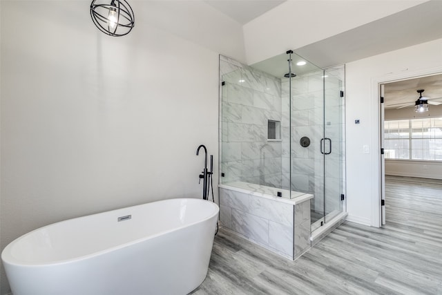 bathroom with ceiling fan, wood-type flooring, and plus walk in shower