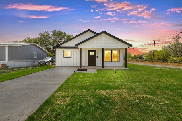 modern farmhouse style home featuring a lawn